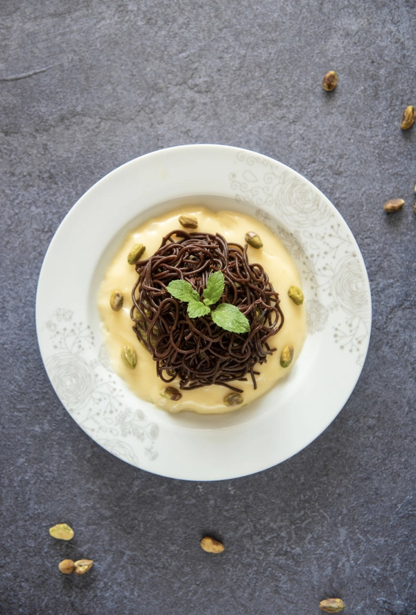 chocolate spaghetti with vanilla sauce and pistachio cream